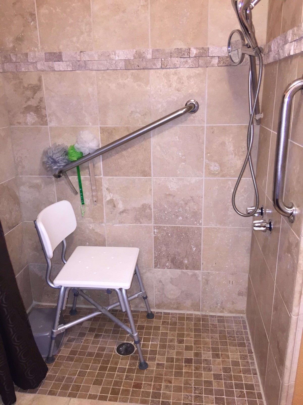 Accessible shower with a chair and grab bars for safety.