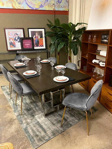A stylish dining area featuring a modern table set for dinner, complemented by decorative art and indoor plants.