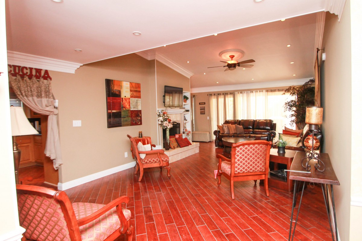 A warm and inviting living room with wooden floors, comfortable seating, and colorful artwork.