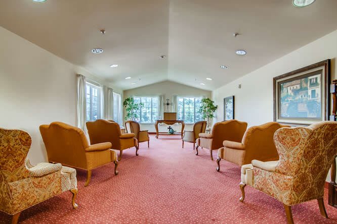 A cozy lounge area with upholstered chairs and large windows.