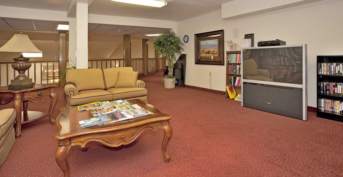 A cozy waiting room with a sofa, coffee table, and various reading materials.