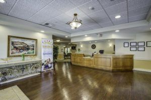 A well-lit reception area with wooden flooring and front desk.