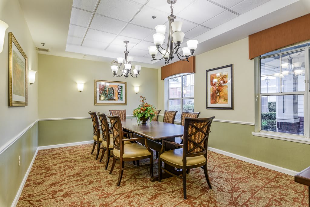 Elegant dining room with a large table, ornate chairs, and decorative chandeliers.