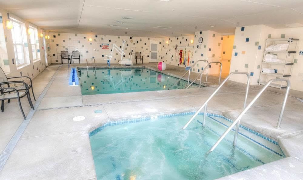 Indoor swimming pool and hot tub facility with a relaxing atmosphere.