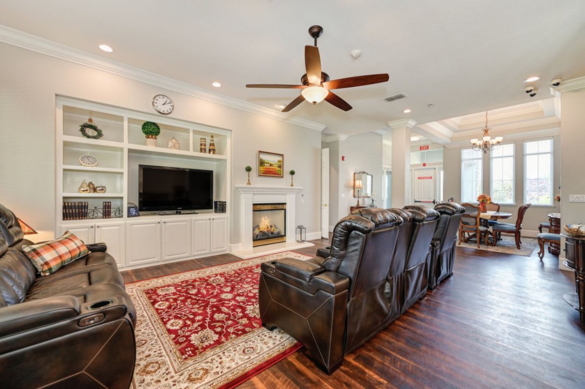 A cozy living room featuring leather recliners, a large television, and a fireplace.