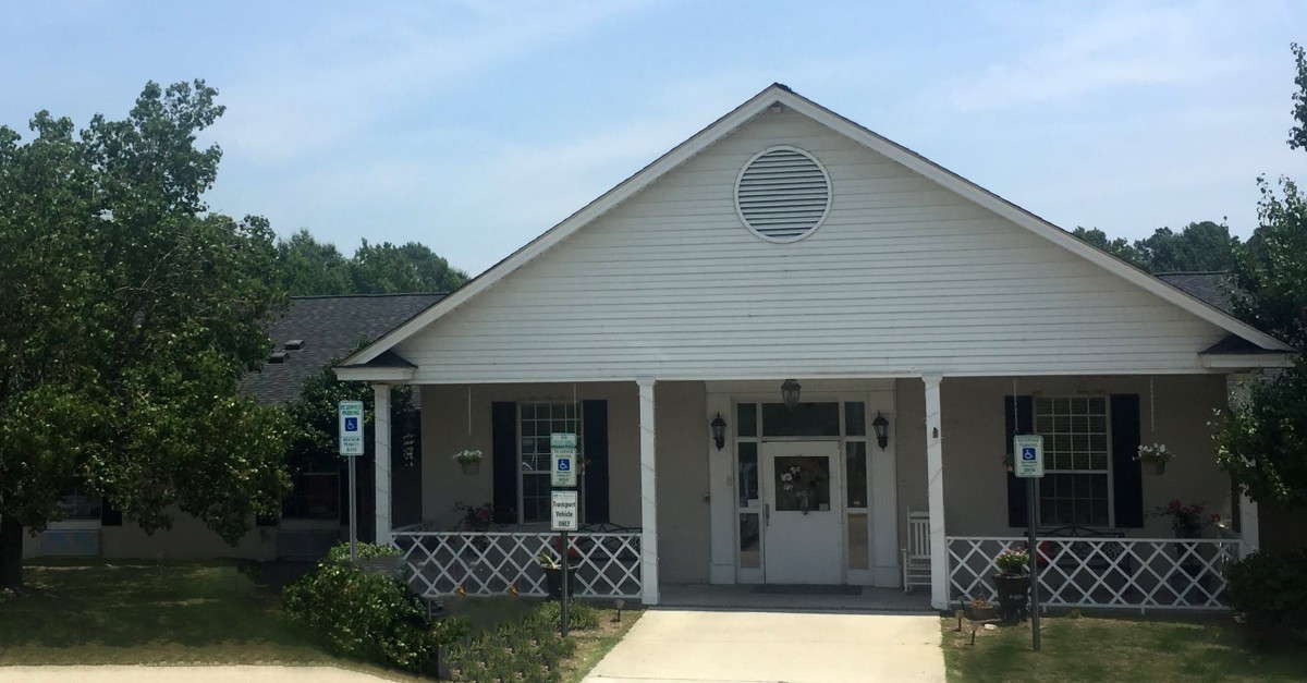 A small white building with a front porch and accessibility ramp.