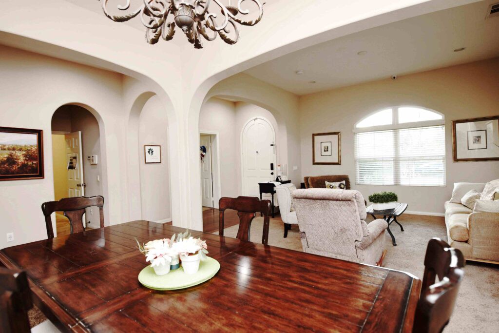 A spacious living and dining area with elegant furniture and arched doorways.