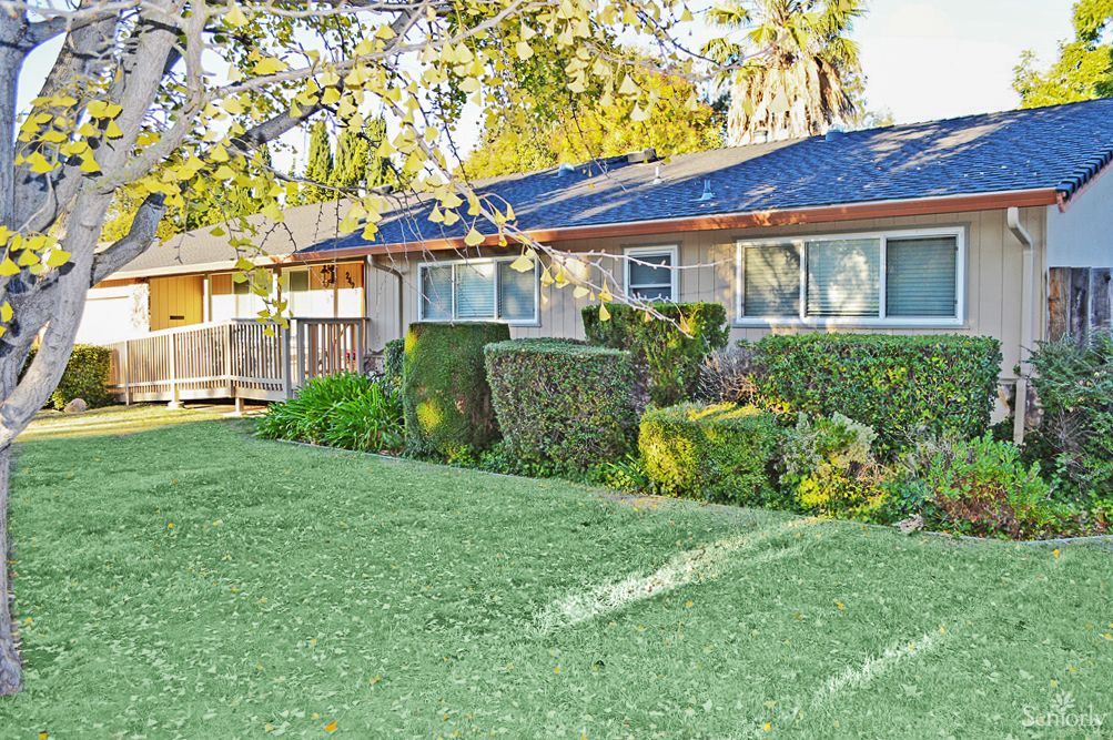 A suburban home with a well-maintained lawn and neatly trimmed bushes.