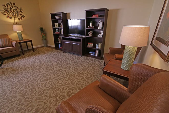 A cozy living room with bookshelves, a television, and comfortable seating.