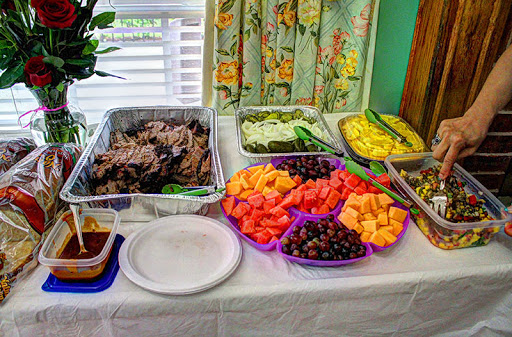 A colorful spread of delicious food featuring a variety of fruits and savory meats, perfect for a gathering.