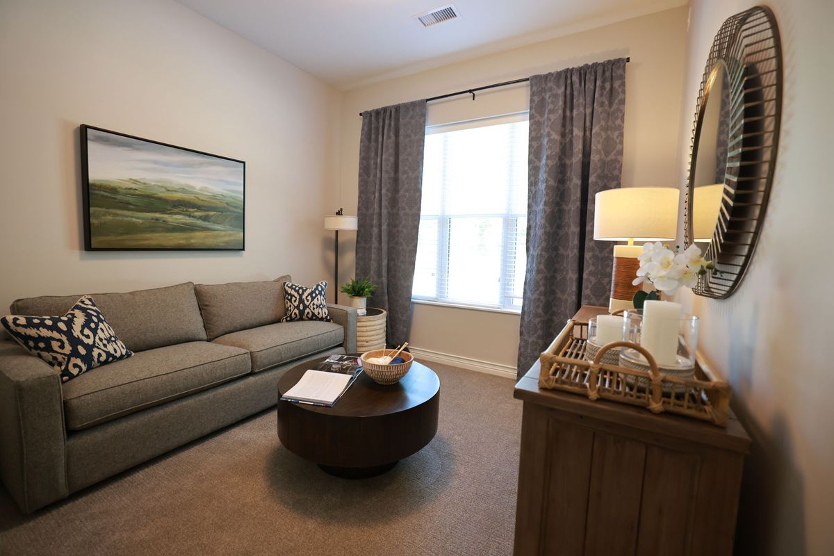 A cozy living room with a comfortable sofa, round coffee table, and decorative elements such as artwork and lamps.