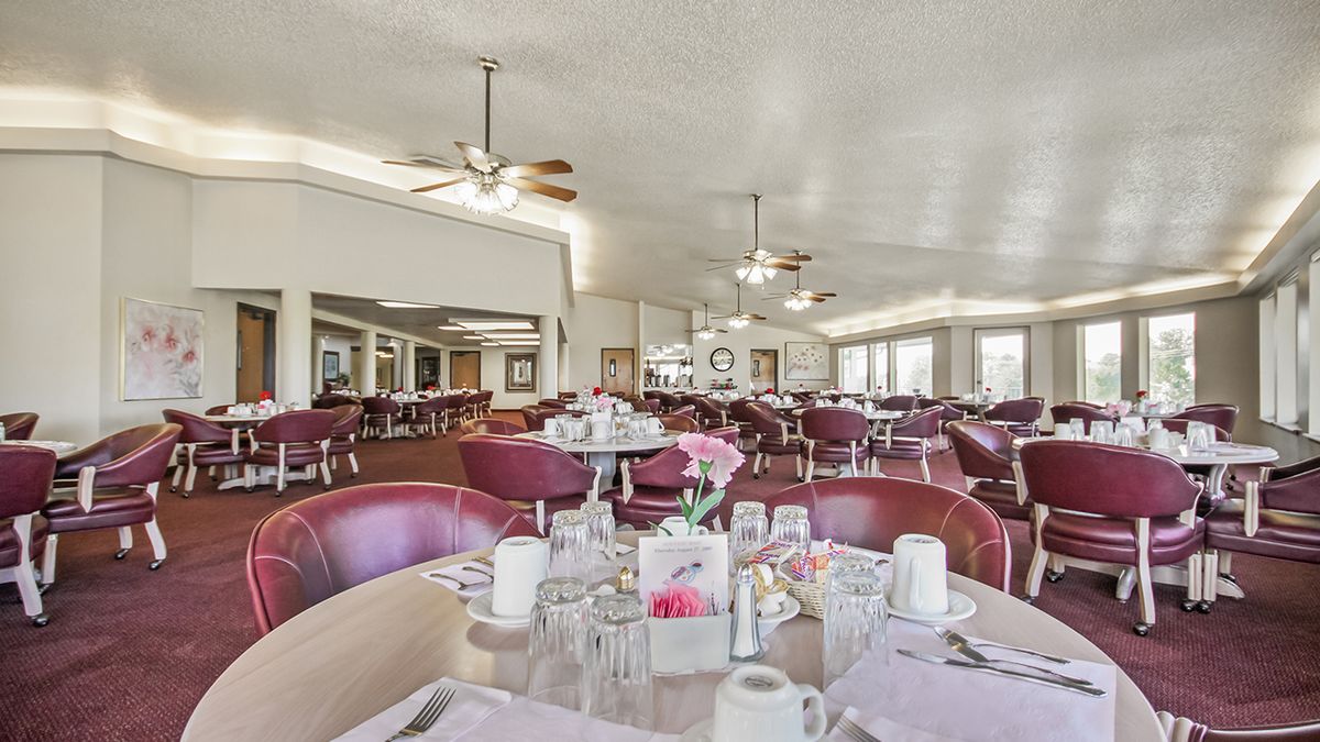 A spacious dining area with elegantly set tables and comfortable seating.