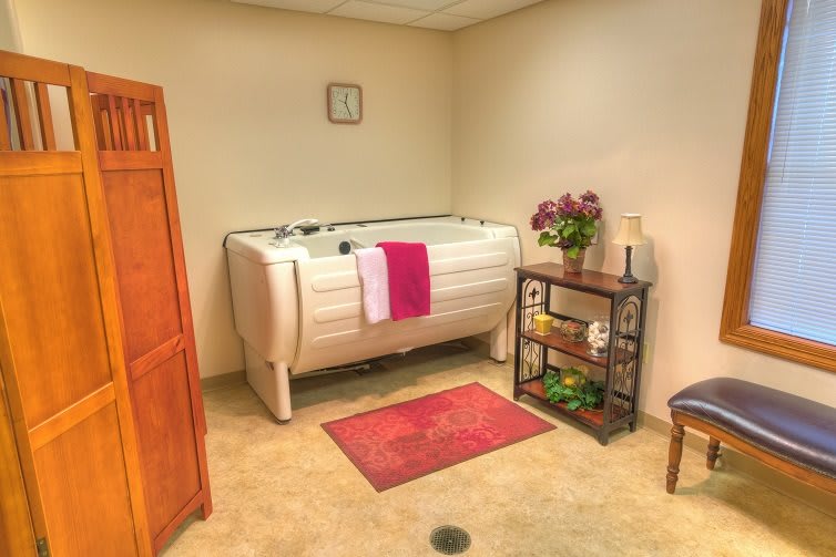 A cozy bathroom interior featuring a bathtub, decorated with plants and neatly arranged towels.