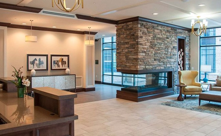 A modern lobby with a stone fireplace and reception area.