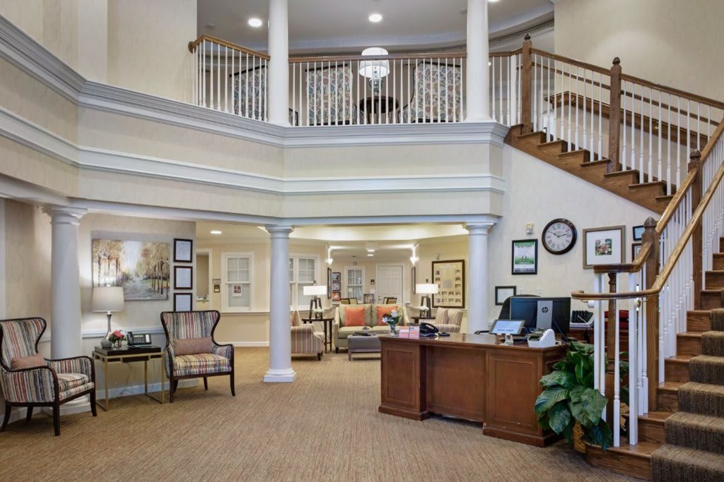 A spacious and elegantly designed lobby area with a reception desk, seating, and decorative elements.