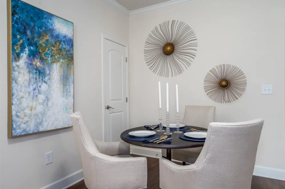 A modern dining room with a round table, stylish wall decor, and elegant seating.
