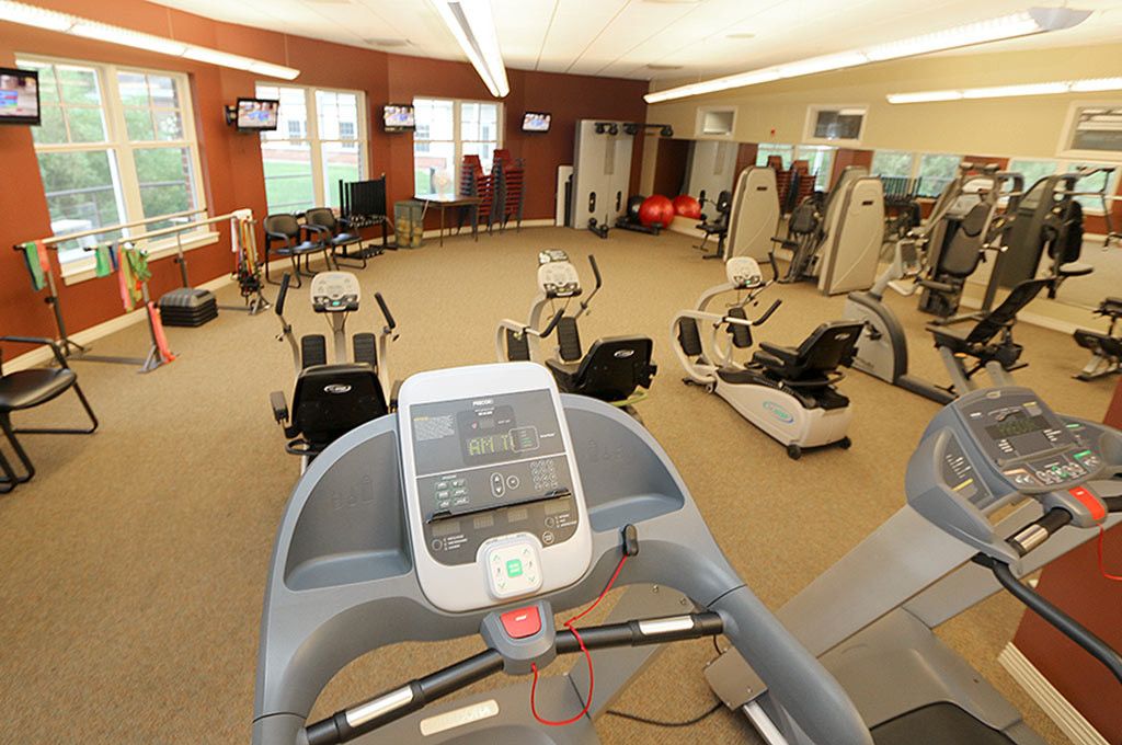 A well-equipped gym featuring treadmills, ellipticals, and other exercise machines.