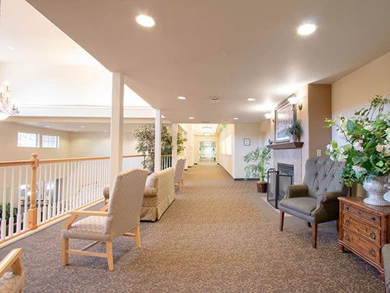 A well-lit hallway with comfortable seating and decorative plants.