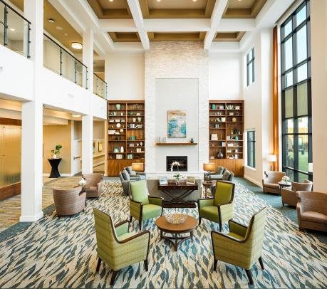 A spacious and elegantly designed lobby with modern furniture and a cozy fireplace.