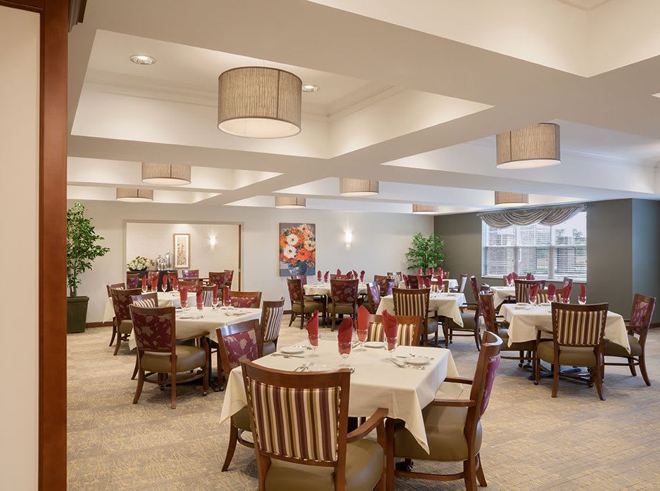 A well-lit restaurant dining area with neatly arranged tables and chairs.