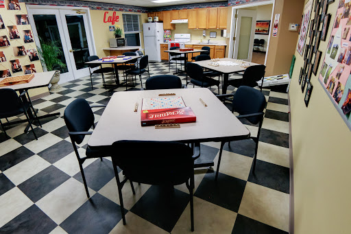 A cozy kitchen and dining area with tables and chairs, featuring a checkered floor.