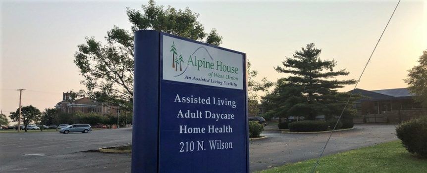 A sign for Alpine House, advertising assisted living, adult daycare, and home health services.
