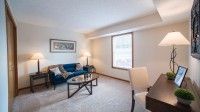 Cozy living room with a sofa, coffee table, and large window allowing natural light.