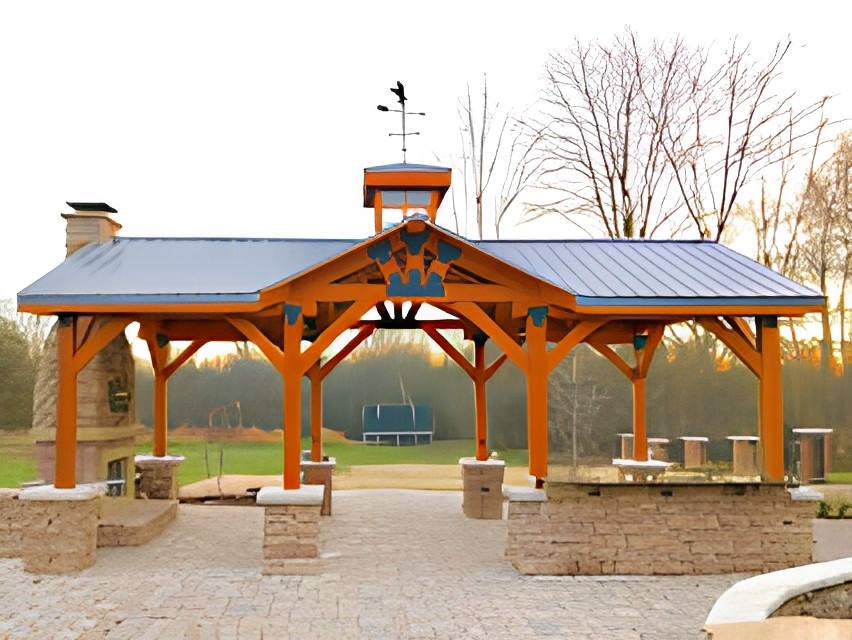A wooden pavilion set in a park landscape, featuring a weathervane on top.
