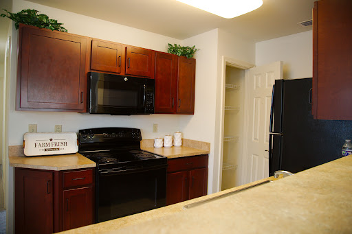 A modern kitchen featuring black appliances and wooden cabinets.