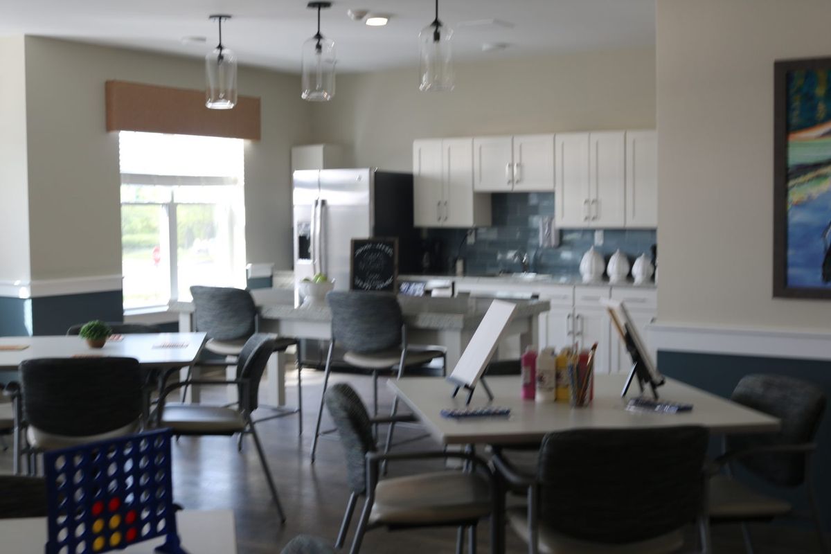 A modern kitchen and dining area with tables and chairs, featuring bright lighting and sleek design.