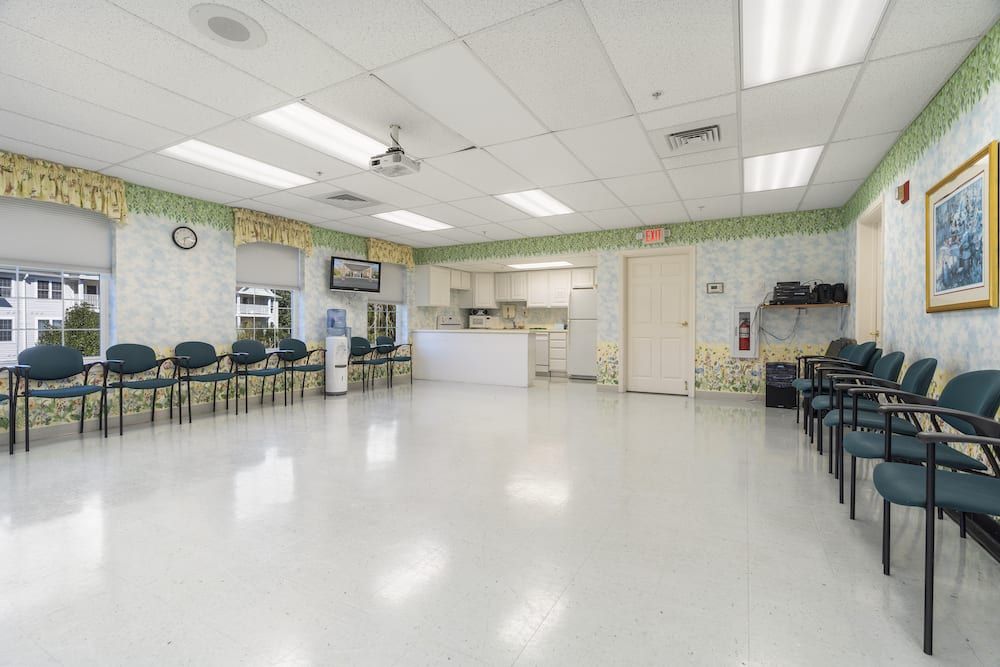 An empty waiting room with chairs and a reception desk.