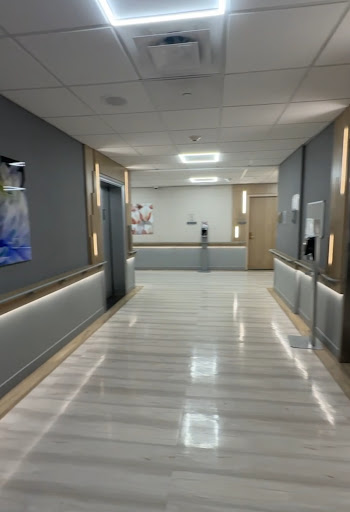 A modern hospital corridor featuring sleek design and ambient lighting.