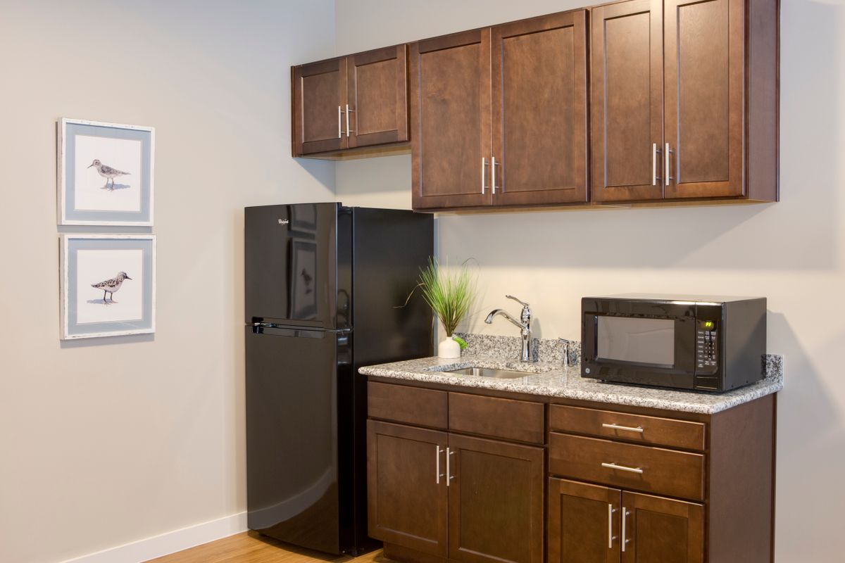 Modern kitchen with wooden cabinets and essential appliances.