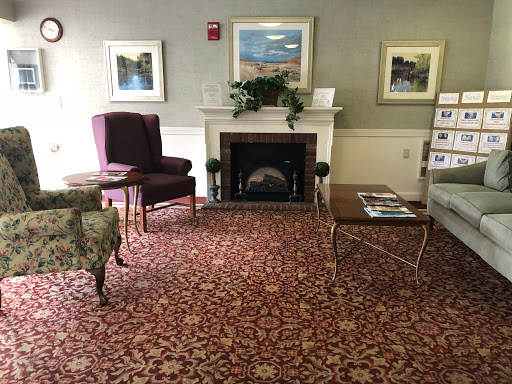 A cozy lobby area featuring comfortable seating, a decorative fireplace, and elegant artwork.