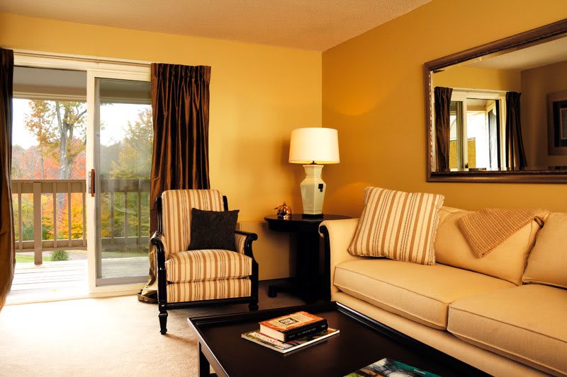 A warm and inviting living room with a comfortable sofa, patterned armchairs, and a stylish lamp.