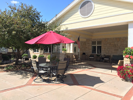 A cozy outdoor patio with a red umbrella, perfect for enjoying a sunny day.