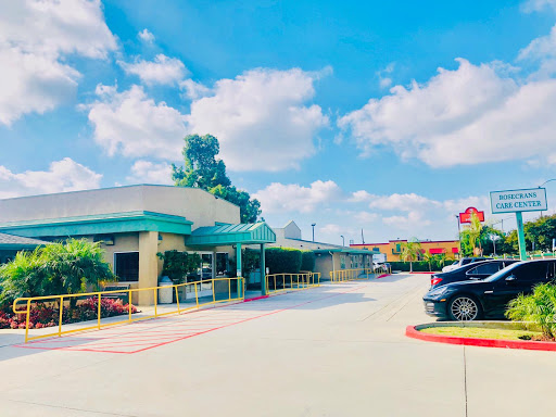 A sunny day at a hotel entrance with clear blue skies and fluffy clouds overhead.