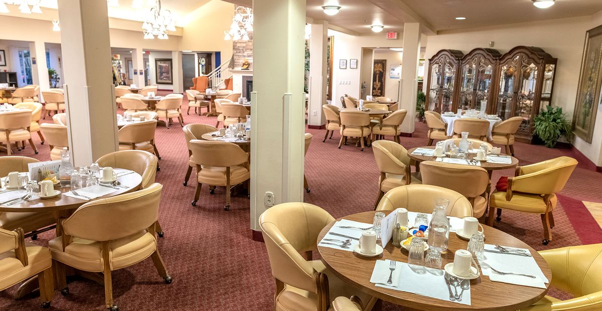A cozy dining area with neatly set tables and comfortable seating.