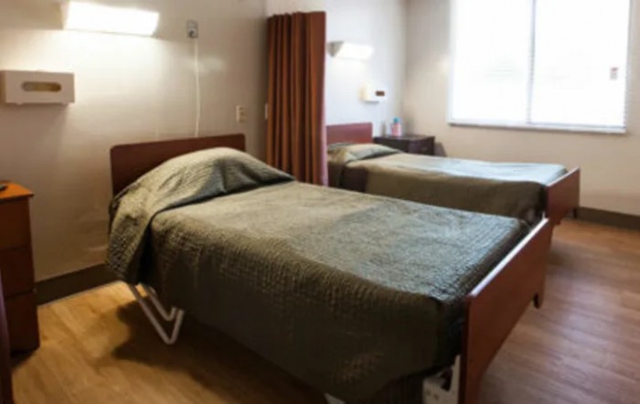 A clean and organized hospital room with a bed and privacy curtain.