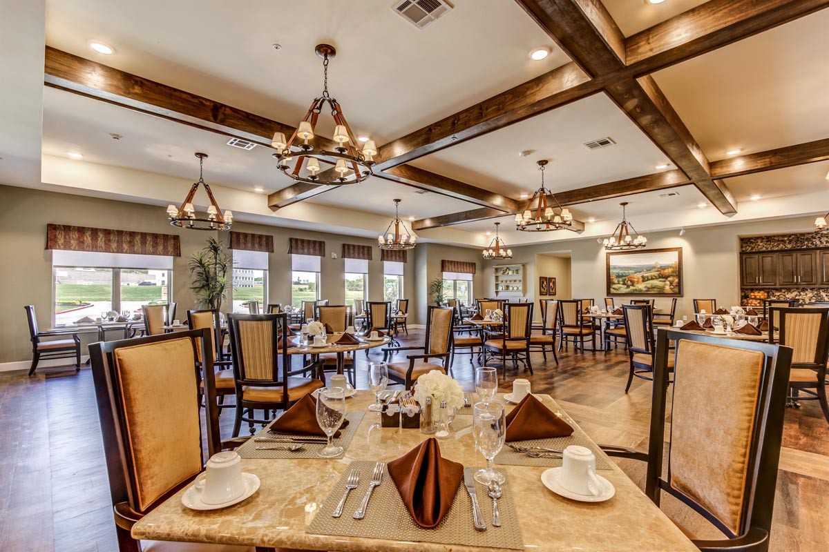 An elegant restaurant interior with neatly arranged tables and chandeliers.