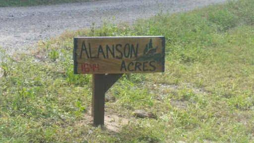 A wooden sign marking the entrance to Alanson Acres.
