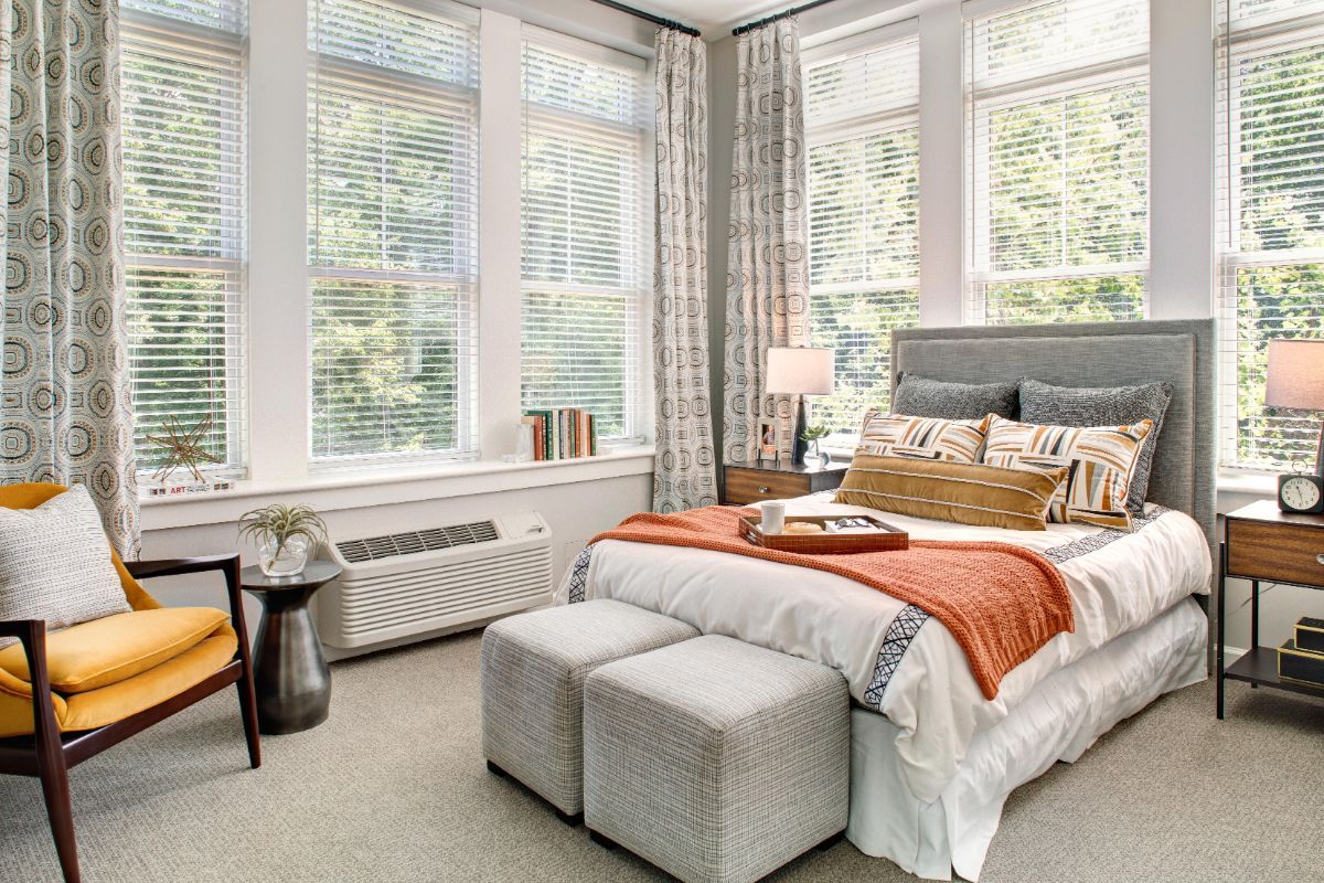 A modern bedroom with large windows and stylish decor.