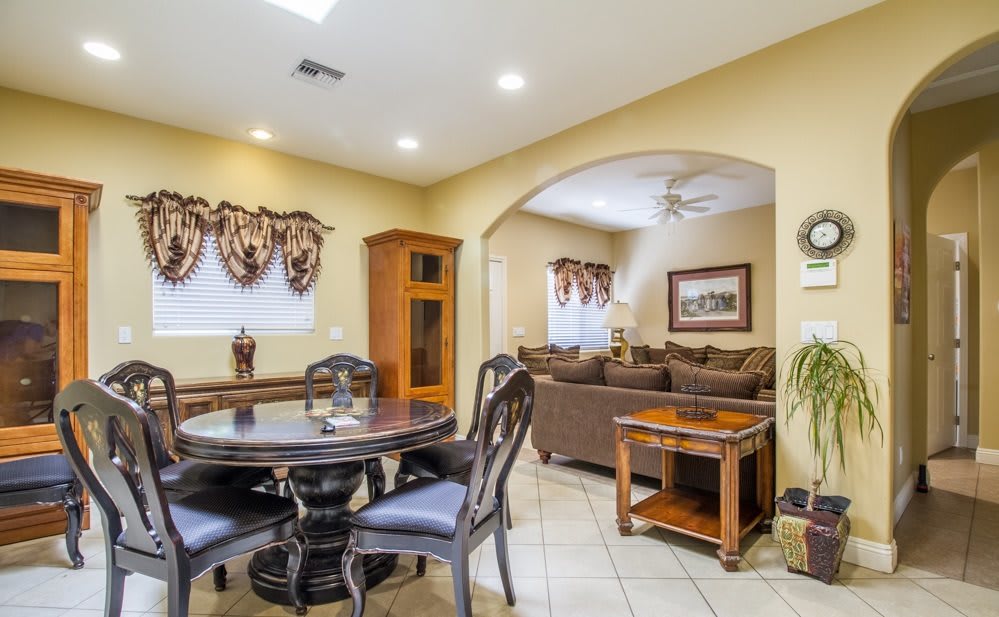 A cozy living room with a dining area, featuring a round dining table and chairs, a comfortable sofa, and tasteful decorations.