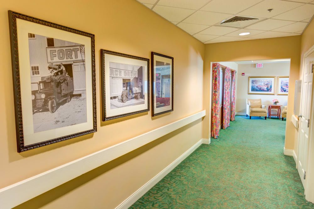 A warmly lit hallway with framed artwork adorning the walls.