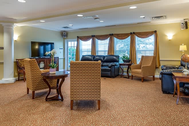 A cozy living room with comfortable seating and large windows adorned with curtains.