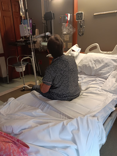 A patient sitting on a hospital bed, receiving treatment.