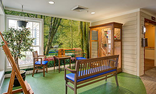 A cozy waiting room with wooden benches, a forest-themed mural, and warm lighting.