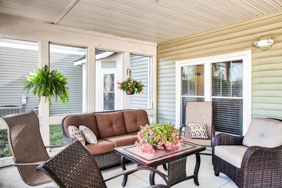A cozy sunroom with comfortable seating and vibrant plants.