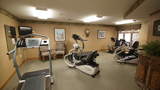 A well-equipped indoor gym featuring various exercise machines and a comfortable workout environment.