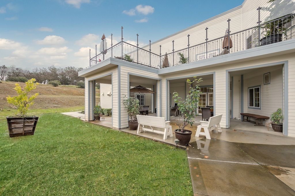 A modern house with a spacious patio and well-maintained lawn.